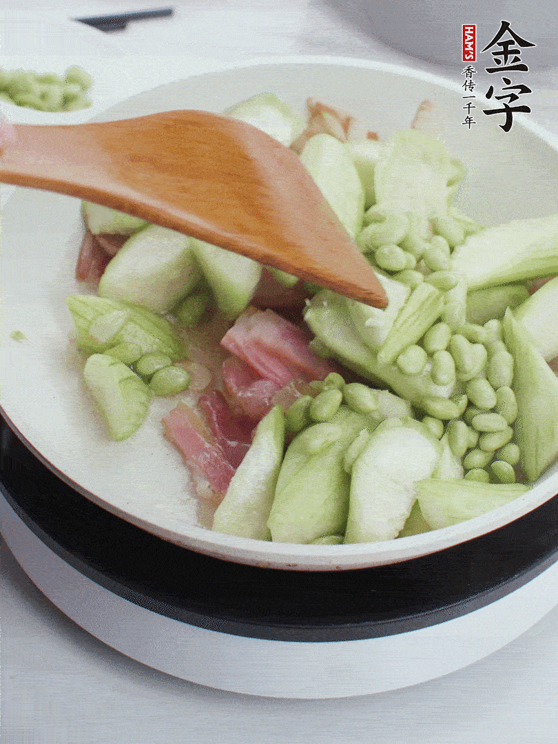 依次下絲瓜、青豆翻炒，炒至絲瓜打蔫縮小。